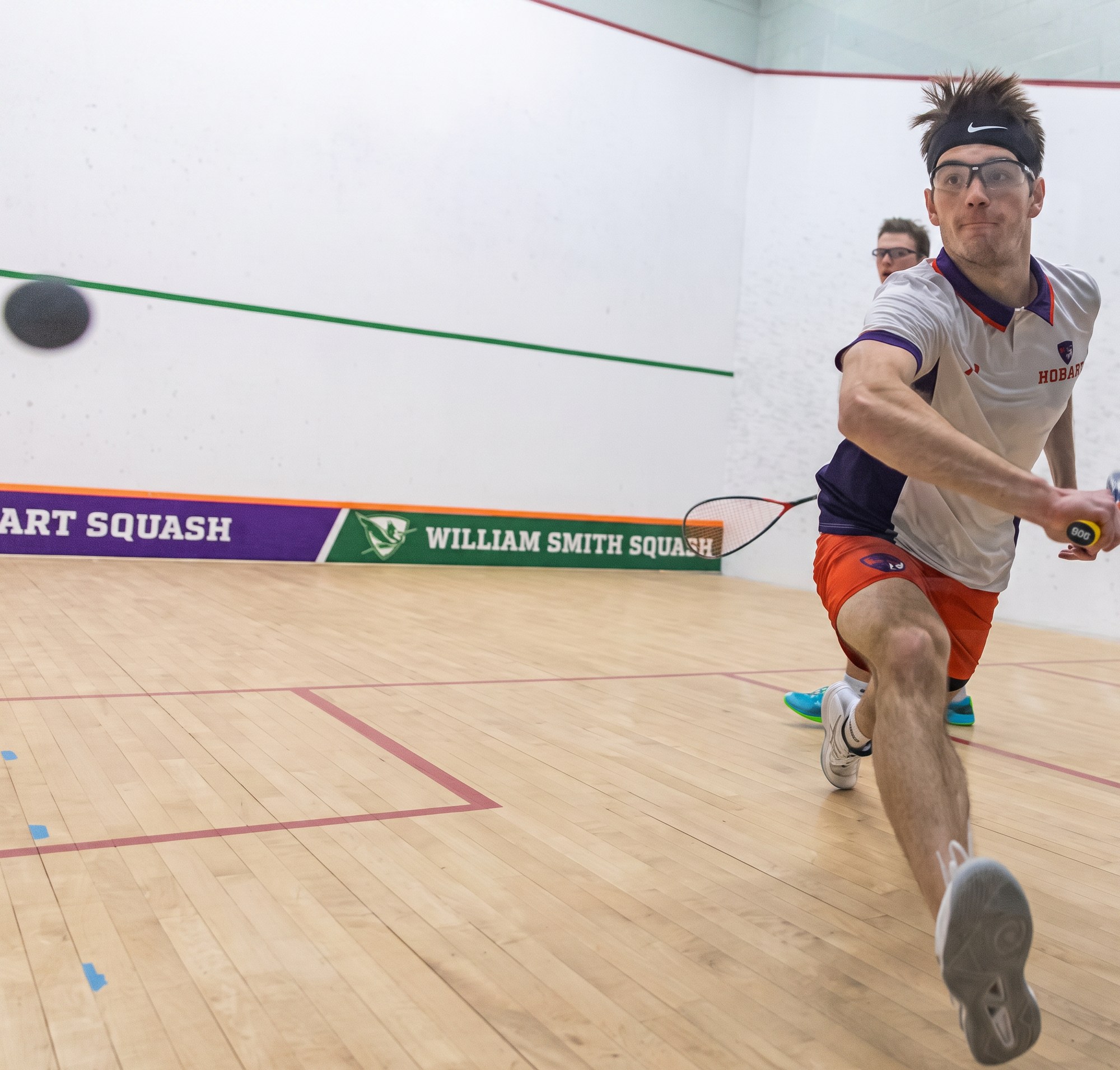 Competitive squash action during an adult match